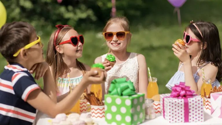 Girls party outside and eating cupcakes