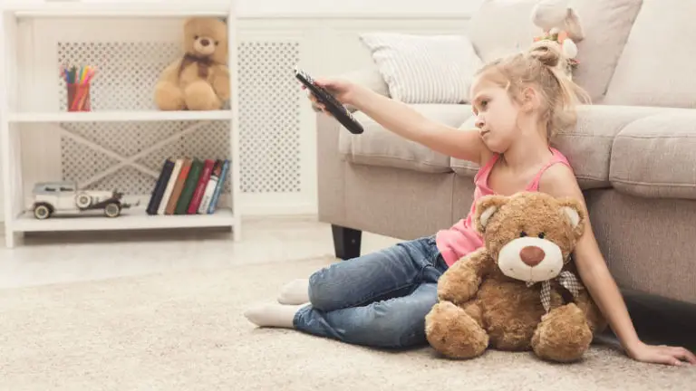 Bored girl sitting on floor with teddy bear