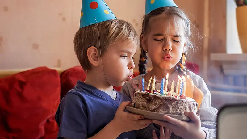 bids blowing candles of a cake