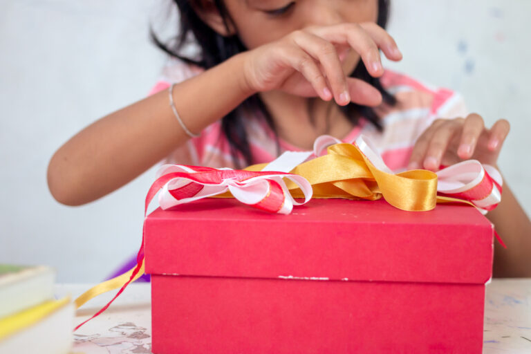 Asian little girl wrapping gift box