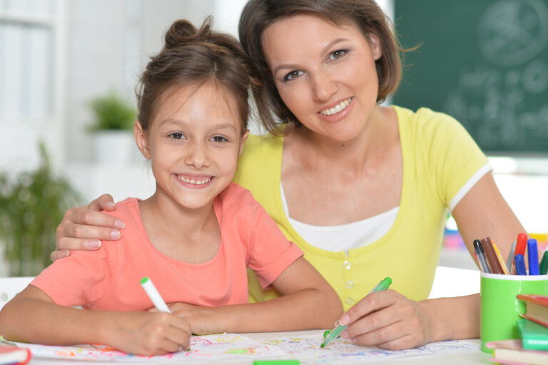 Cute girl with mother drawing at home