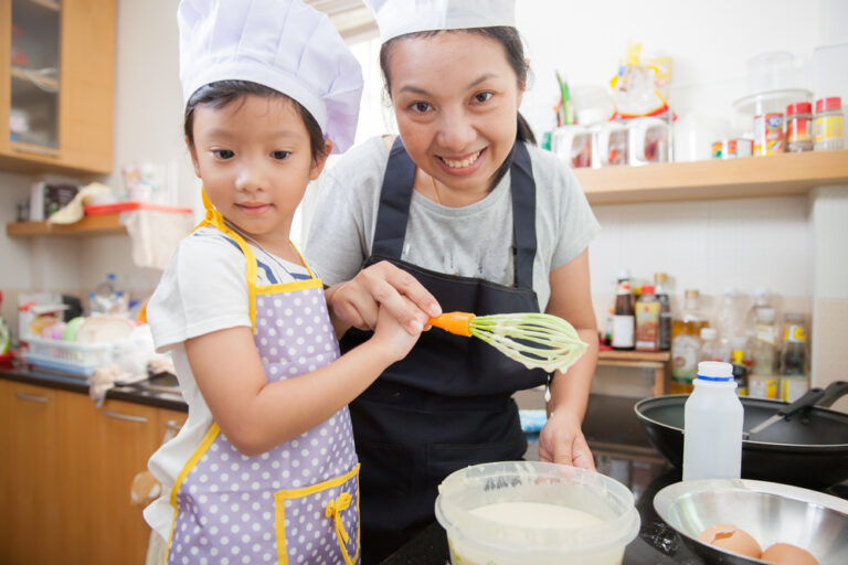 Little asian girl making pancake