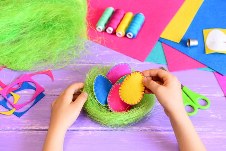 Small child makes a simple Easter decoration with craft items