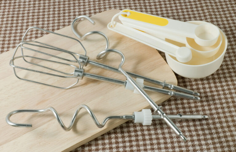 Measuring Spoons and Metal Whisking on Wooden Board