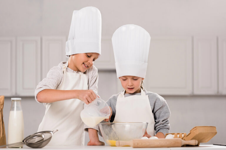 Boy pouring milk into bowl while sister standing